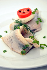 some fresh organic herring on a white plate