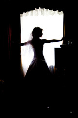 silhouette of bride looking out a window