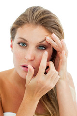 Concentrated woman putting a contact lens