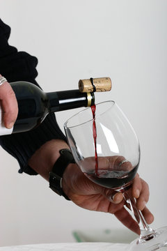 sommelier en train de verser du vin rouge dans un verre