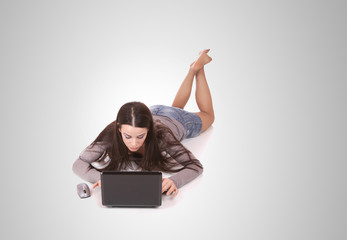 casual woman with a laptop, working on the floor.