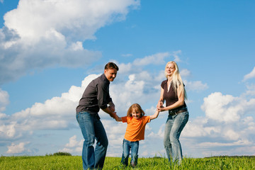 Familie läuft über Wiese im Sommer