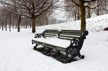 A lonely bench covered in deep snow