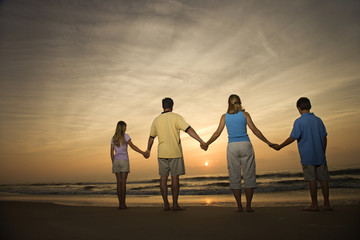 Family holding hands on beach