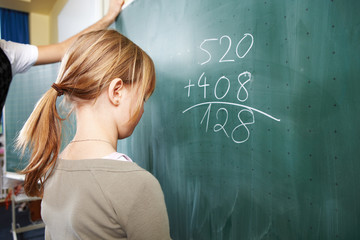 Schülerin schreibt an die Tafel