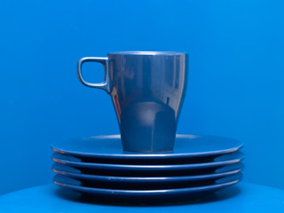 Blue coffee mug on the stack of plates