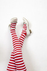 head over heels. female legs in stripy stockings;