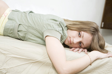 Obraz na płótnie Canvas pensive blond woman lying on bed