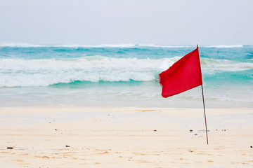 Red flag on tropical beach