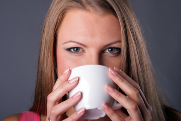 Portrait of the beautiful young girl with a coffee cup