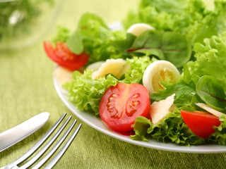 salad with eggs and tomatoes on a green background.