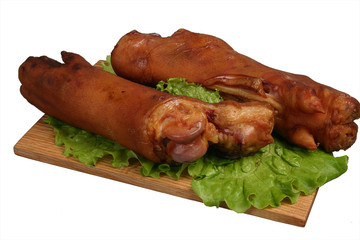 Smoked trotters on wooden board.