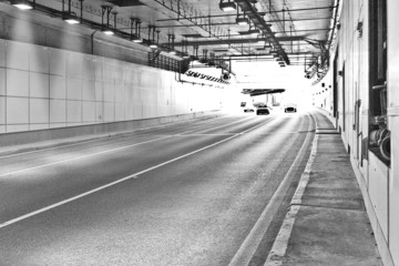 Long lightened tunnel for vehicles. Black and white photogrphy.