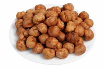 Hazelnuts on a white plate, isolated.