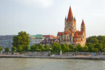 Zelfklevend Fotobehang Mexicoplatz-kerk aan de rivier de Donau, Wenen, Oostenrijk © sborisov