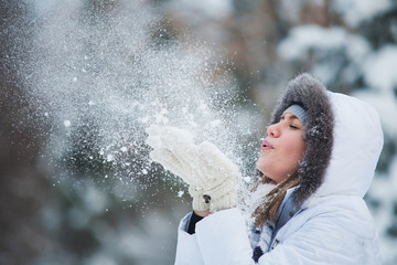 Beautiful woman blowing in the snow - Powered by Adobe