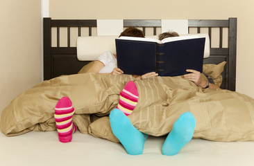 couple reading a book or newspaper