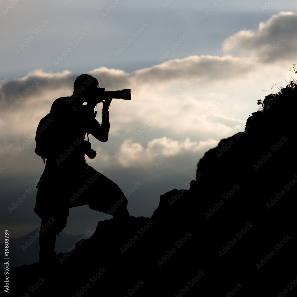 Wall mural silhouette of the photographer on a hillside