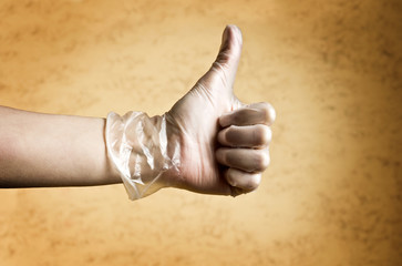 thumb up hand with protective latex glove