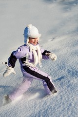 Fototapeta na wymiar Funny little girl running in the snow