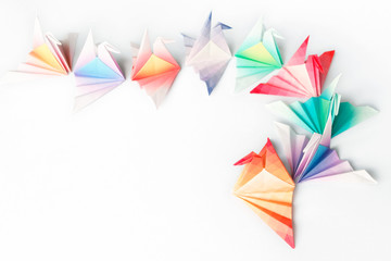 A queue of paper birds on a white background
