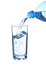 Water falling in glass from bottle