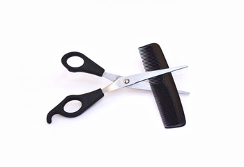 Scissors and comb on white background