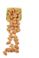 Scattered almond nuts on a cup sliding down