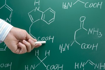 Hand with chalk showing chemical formula