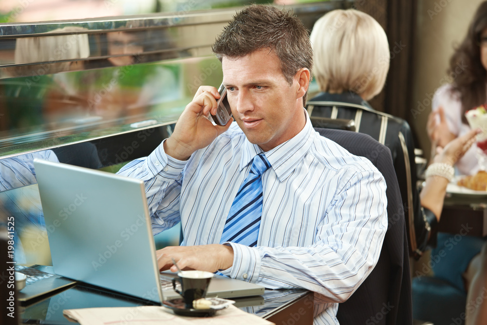 Wall mural businessman using laptop in cafe