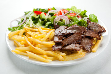 Grilled meat with fried potatoes and vegetables