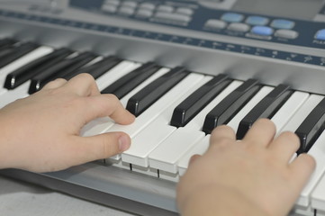 Fototapeta na wymiar boys hands playing piano keyboard