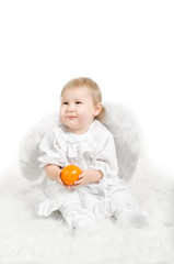 Little white child an angel with orange fruit