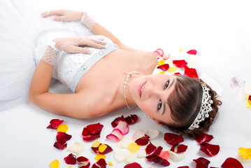 Obraz na płótnie Canvas Beautiful sexy bride on floor among red rose petals