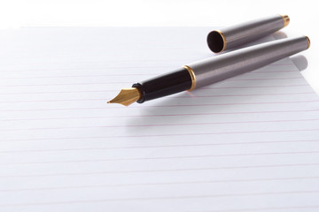 Fountain pen lying on page in a spiral bound notepad