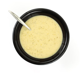 Cream of broccoli soup in black bowl with spoon