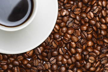 A cup of coffee on coffee beans