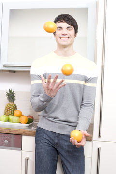 mann jongliert mit orangen