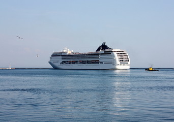 white cruise ship leaving a  port