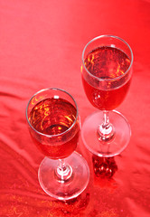 Two glasses of wine on red background