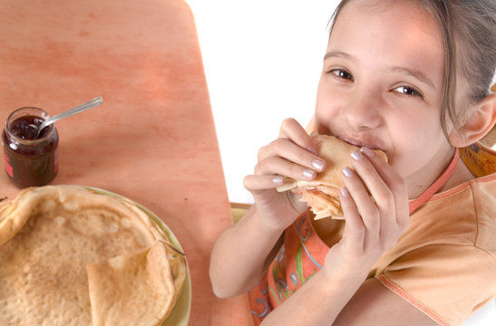 enfant rieuse qui mange une cr&ecirc;pe - vue d'en haut