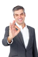 Smiling mature businessman showing OK sign
