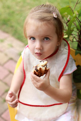 Lovely girl and eating pastry outdoor