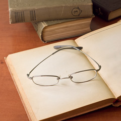 Open antique books with glasses