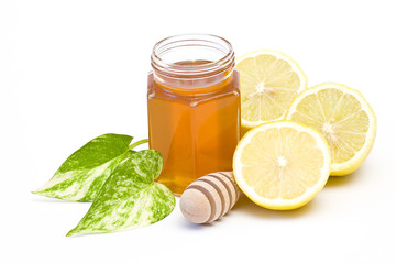 jar of honey, lemon and wooden drizzler