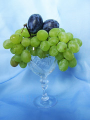 Grapes and plums in a glass