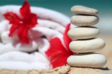Stack of white stones with towel and flower in background