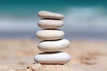 Fototapeta na wymiar Stack of white stones composed as tower on the beach