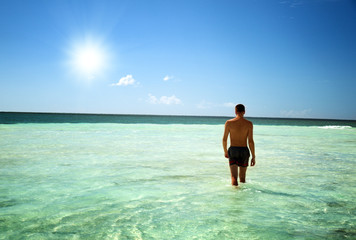 young man walking in Caribbean sea