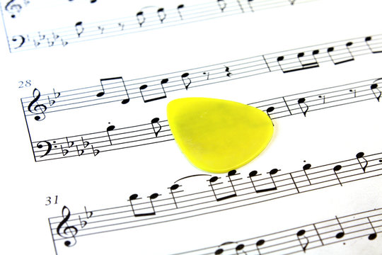 Music Note Paper With Yellow Guitar Pick